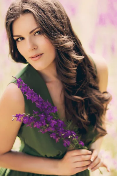 Kvinna med violetta blommor — Stockfoto