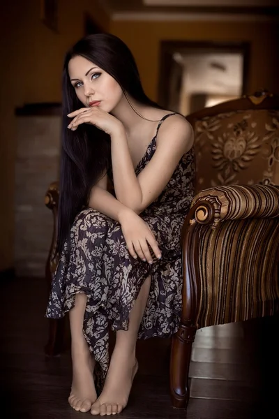 Vacker kvinna sitter i en fåtölj — Stockfoto