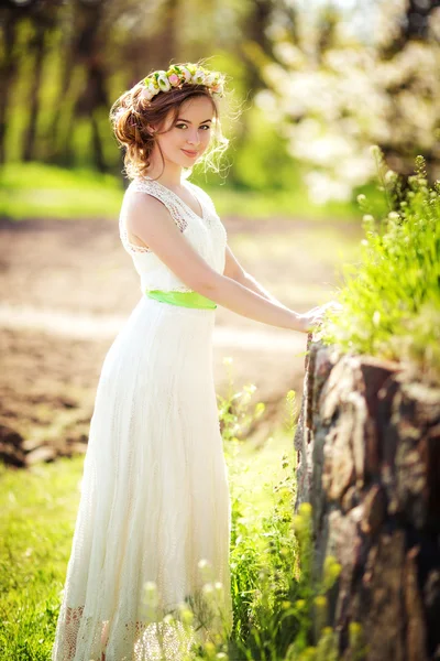 Mulher em grinalda posando no jardim da primavera — Fotografia de Stock