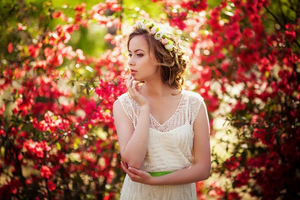 Mulher em grinalda posando no jardim da primavera — Fotografia de Stock