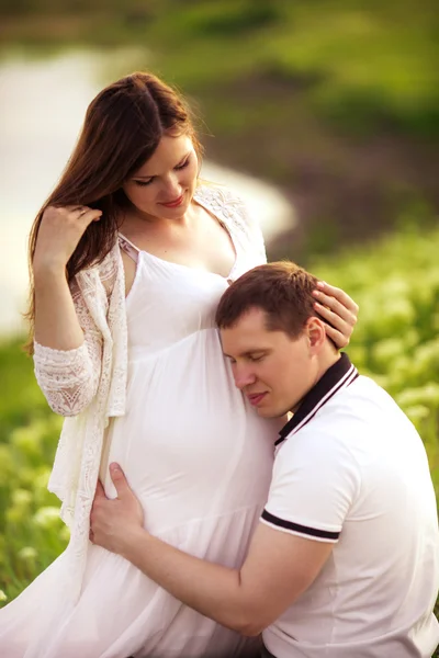 Donna incinta con il marito in giardino — Foto Stock