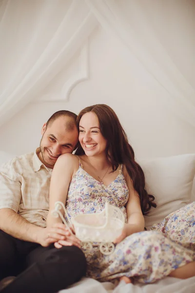 Zwangere vrouw en haar echtgenoot in de slaapkamer — Stockfoto