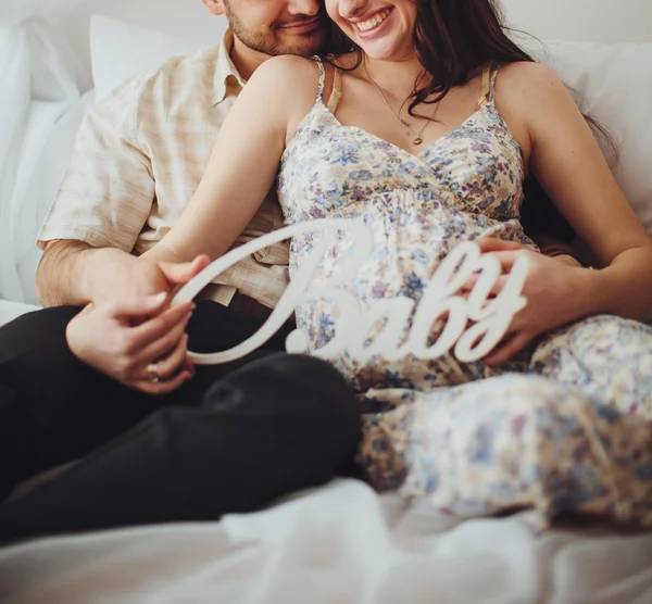 Mujer embarazada y su marido en el dormitorio — Foto de Stock