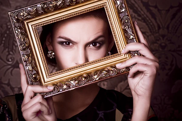 Mode vrouw poseren met gouden frame — Stockfoto