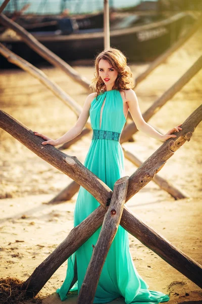 在一个海滩上的长长的蓝色裙子的女孩 — 图库照片