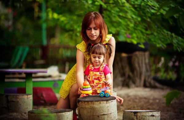Mor med flicka på vårträdgård — Stockfoto