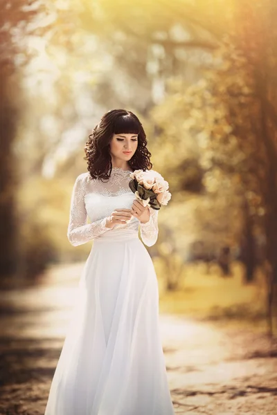 Sposa con un bouquet posa all'aperto — Foto Stock