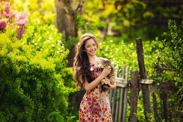 春の庭の猫を持つ女性 — ストック写真