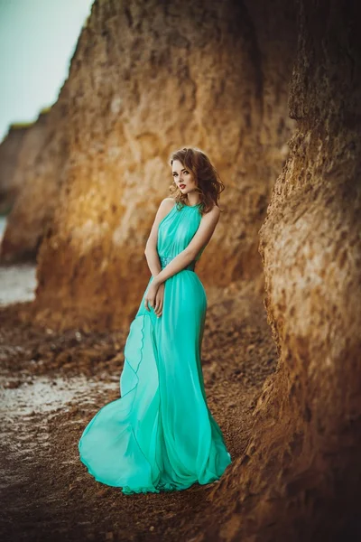 Bir sahil üzerinde uzun mavi elbiseli kız — Stok fotoğraf