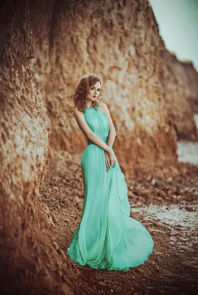 Bir sahil üzerinde uzun mavi elbiseli kız — Stok fotoğraf