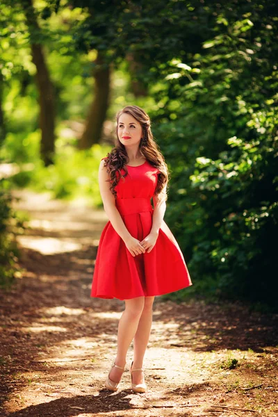 Vrouw in rode jurk buiten — Stockfoto