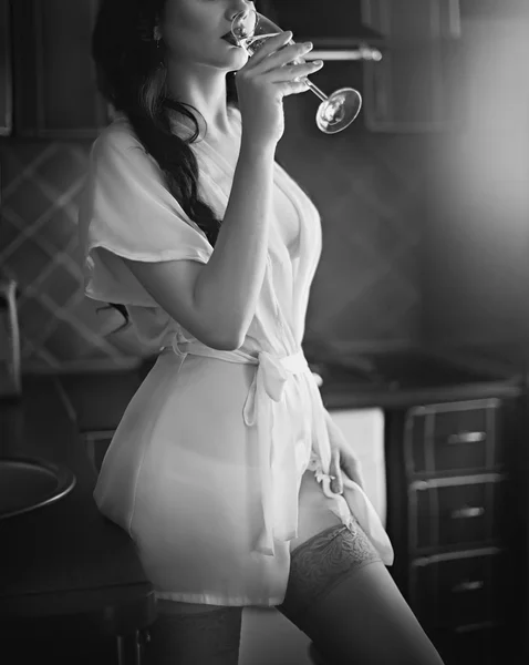 Chica morena bebiendo vino en la cocina — Foto de Stock