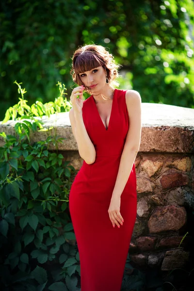 Donna in abito rosso in giardino primaverile — Foto Stock