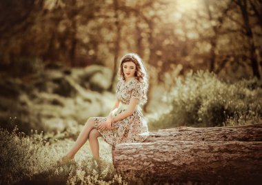 bir orman içinde ahşap üzerinde oturan kadın