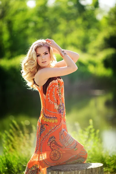 Blonde woman sitting near the river — Stock Photo, Image