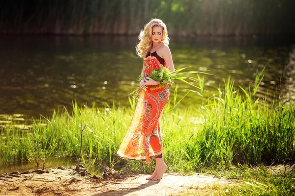 Donna con erbe nelle mani vicino al fiume — Foto Stock