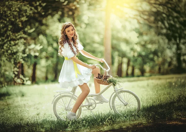 Kvinna med cykel i vårträdgård — Stockfoto