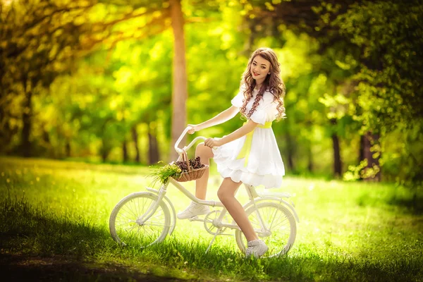 Жінка з велосипедом у весняному саду — стокове фото