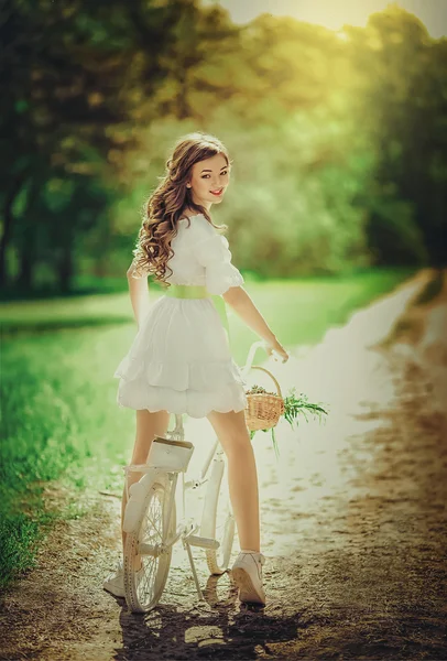 Femme avec vélo dans le jardin de printemps — Photo