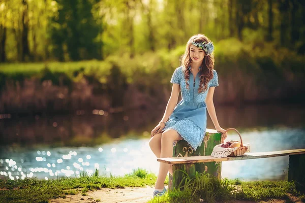 Jonge vrouw zitten in de buurt van de vijver — Stockfoto