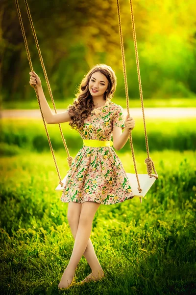 Woman sitting on a swings outdoor — Stock Photo, Image