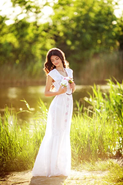 Vrouw in witte jurk die zich voordeed op de weide — Stockfoto