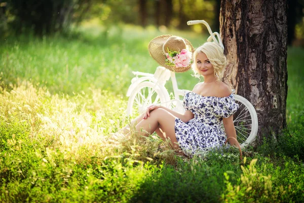 Mulher com bicicleta no jardim da primavera — Fotografia de Stock