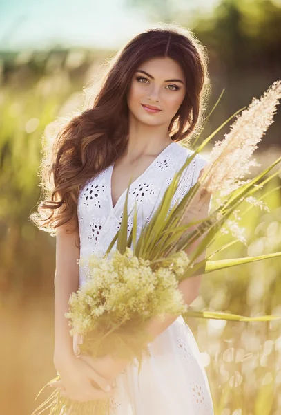 Donna in abito bianco in posa sul prato — Foto Stock