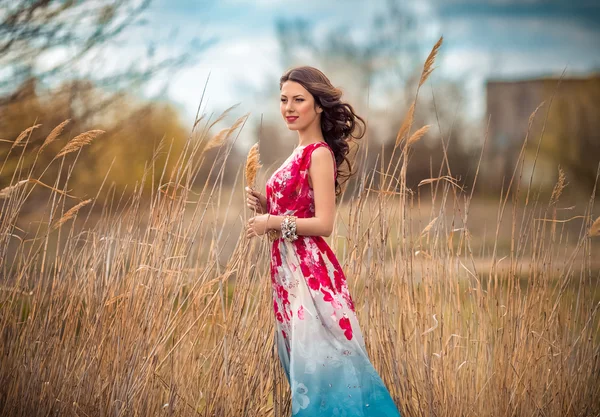 Vrouw in lange jurk buiten — Stockfoto