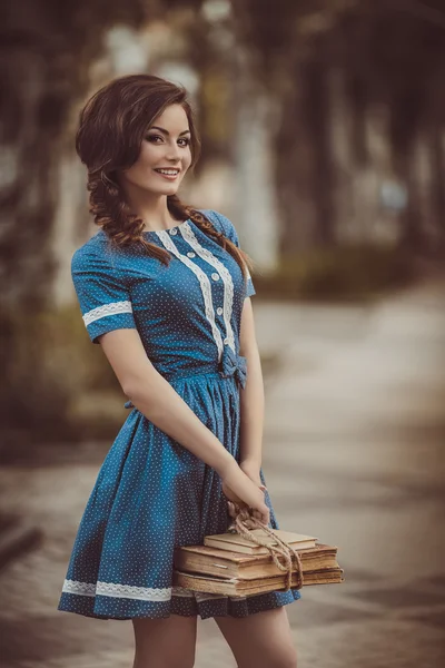 Donna con libri in giardino primaverile — Foto Stock