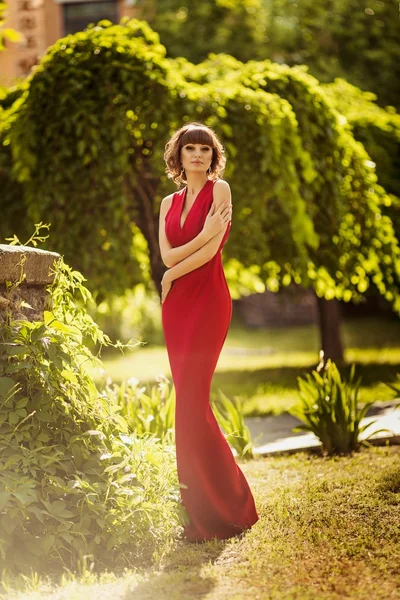 Vrouw in rode jurk in lentetuin — Stockfoto