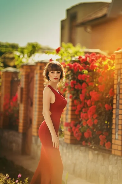 Vrouw in rode jurk in lentetuin — Stockfoto