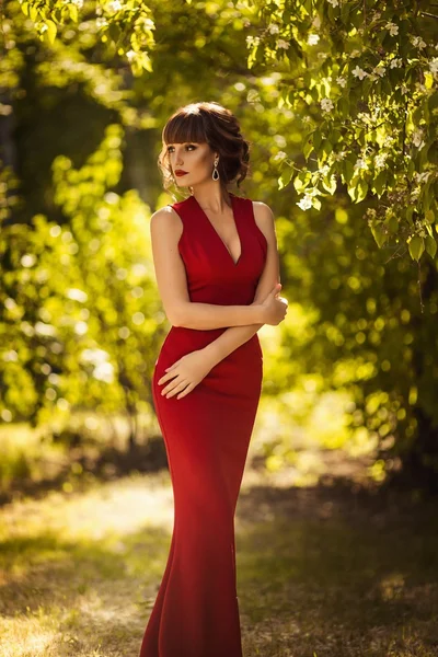 Frau in rotem Kleid im Frühlingsgarten — Stockfoto