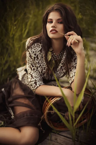 Mujer elegante sentada en la orilla del río — Foto de Stock