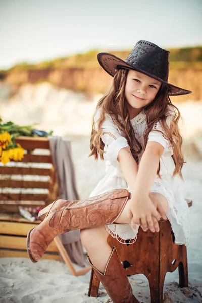 Jong meisje in cowboy laarzen en hoed — Stockfoto