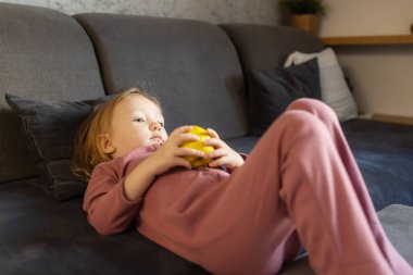 Elmalı aç kız. Bulanık yemek odası arka planı. Çocuklar için sağlıklı beslenme. Çocuk beslenmesi.