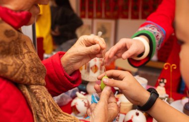 Çin Yeni Yıl mum atölyesi - geleneksel bayram sembolleri ve kırmızı kağıttan Çince karakterler yaratmak. Kültürel sanatlar etkinliği Ay Yeni Yıl Geleneklerini kutluyor