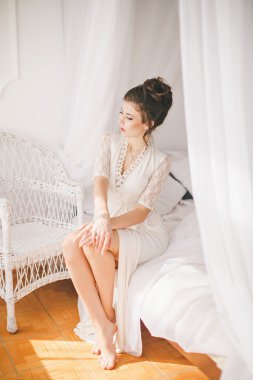 Kız beyaz yatak odasında çamaşır grupları