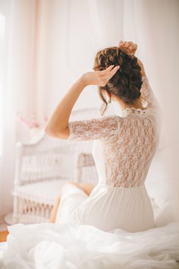 Kız beyaz yatak odasında çamaşır grupları