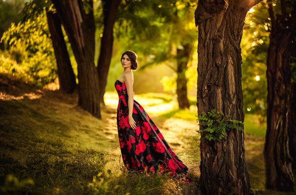 Beautiful woman in long dress in spring garden