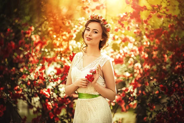 Женщина в венке позирует в весеннем саду — стоковое фото