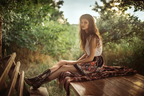 Mujer en ropa de moda sentado al aire libre — Foto de Stock