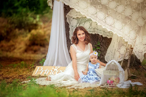 春の庭に女の赤ちゃんを持つ母親 — ストック写真