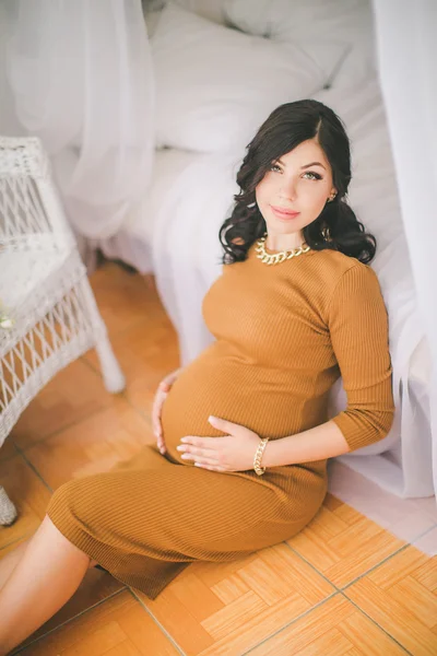 Όμορφη έγκυο γυναίκα σε πορτοκαλί φόρεμα — Φωτογραφία Αρχείου