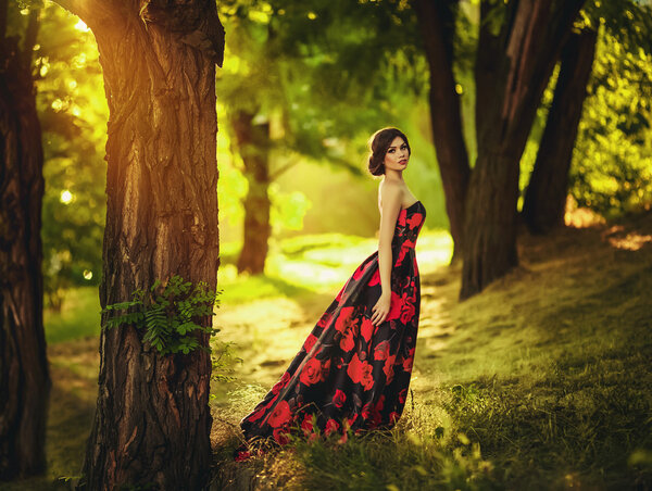 Beautiful woman in long dress in spring garden