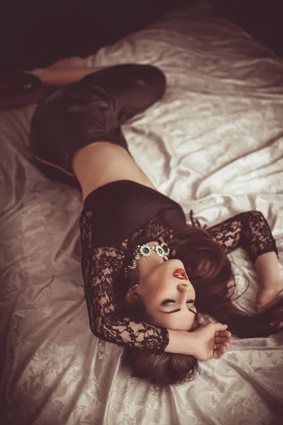Kvinna i modekläder liggande på sängen — Stockfoto