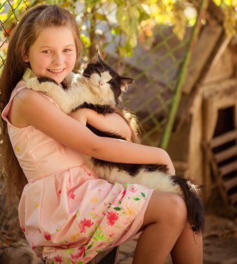 Küçük kız kediyle oynuyor.