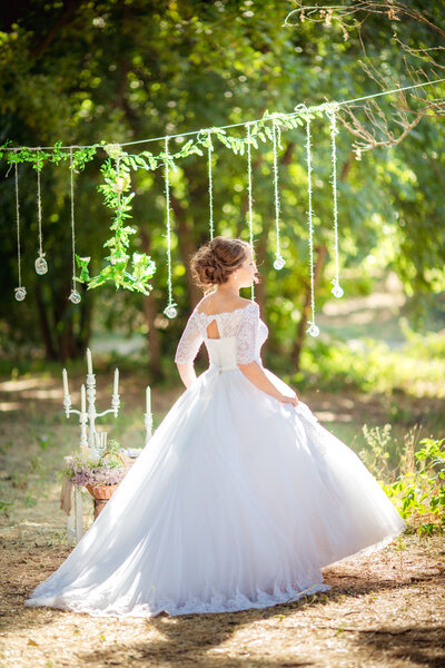 Beautiful romantic bride posing in park at wedding day