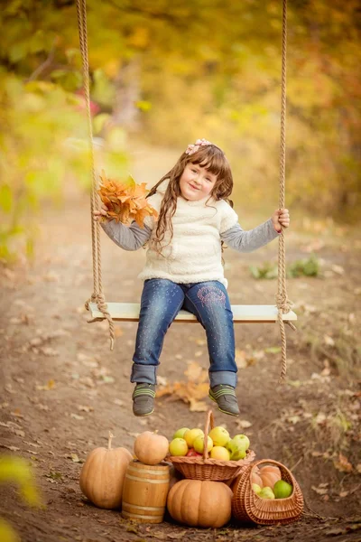Маленькая девочка с качелями и фруктами — стоковое фото