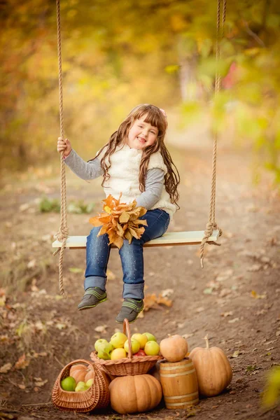 Liten flicka med swing och frukter — Stockfoto